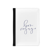 Load image into Gallery viewer, The white front cover of a faux leather passport holder is printed with a lavender coloured script saying 'bon voyage' and has a black spine.