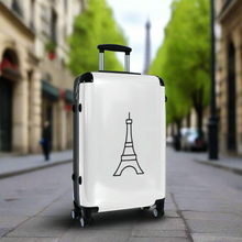 Load image into Gallery viewer, Medium-sized hard-shell suitcase with black Eiffel Tower graphic on white background is accented by black trim, back, wheels and telescoping handle: Boutique L'Abeille Française