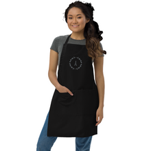 Load image into Gallery viewer, a black canvas apron with a graphic of the Eiffel Tower surrounded by a wreath of flowers embroidered in silver thread: L'Abeille Française