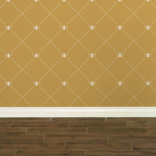 Load image into Gallery viewer, Stylized cream-coloured bees intersecting diagnonal lines on a gold-coloured wallpaper: L'Abeille Française