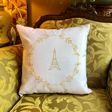 Load image into Gallery viewer, Square, white cushion with a gold graphic of the Eiffel Tower surrounded by a wreath of flowers: L'Abeille Française