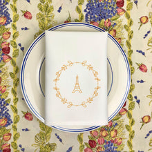Load image into Gallery viewer, White cloth napkin with a gold graphic of the Eiffel Tower surrounded by a wreath of flowers: L'Abeille Française