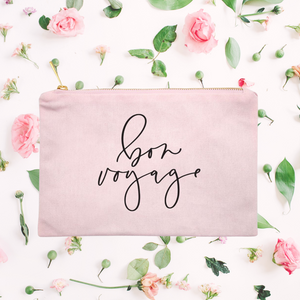 Powder-pink cotton canvas cosmetic bag with 'bon voyage' printed on the front in black script: L'Abeille Française