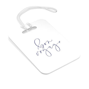 Hard, white plastic luggage tag with Bon Voyage written on it in a lavender blue script