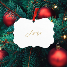 Load image into Gallery viewer, Decorative Christmas ornament with &#39;Joie&#39; in gold on a white background surrounded by red ornaments and green tree branches.