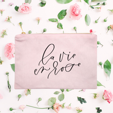 Load image into Gallery viewer, Powder-pink cotton canvas cosmetic bag with &#39;la vie en rose&#39; printed on the front in black script: L&#39;Abeille Française