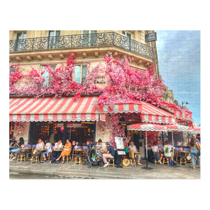 A 252-piece 14" × 11" jigsaw puzzle of the Restaurant La Favorite in Paris bedecked in pink and white striped awnings and festooned with an abundance of pink flowers.