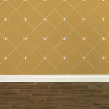Load image into Gallery viewer, Stylized cream-coloured bees intersecting diagnonal lines on a gold-coloured wallpaper: L&#39;Abeille Française