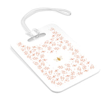 Load image into Gallery viewer, Hard, white plastic luggage tag with gold bee surrounded by pink flowers printed on it 