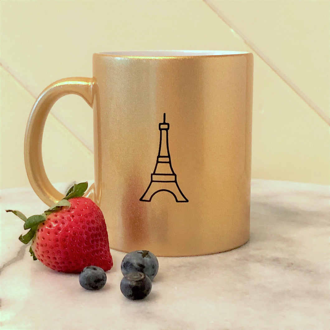 Metallic gold coloured ceramic mug with a black graphic of the Eiffel Tower