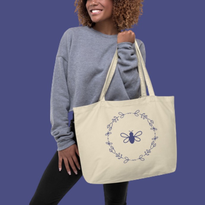 A large natural coloured canvas tote bag with a lavender bee and wreath motif