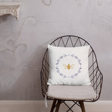 Load image into Gallery viewer, A white cushion with a gold bee surrounded by a lavender flower wreath graphic sitting on a wire chair