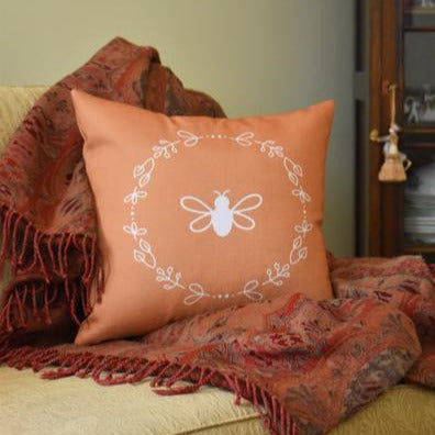 Honey coloured cushion with a bee and wreath motif: L'Abeille Française